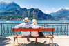 Couple assis sur un banc au bord d'un lac regardant la montagne au loin