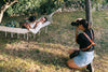 jeune femme photographiant une personne dans un hamac