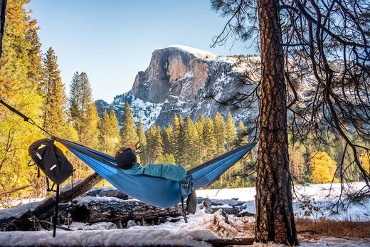 Homme dans un hamac profitant du pittoresque paysage hivernal de Half-dome, dans le parc national de Yosemite.