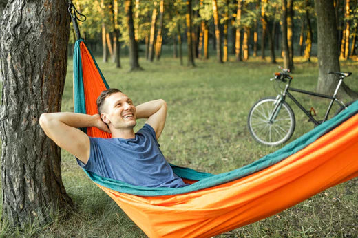homme blanc dans un hamac coloré dans un parc