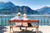 Couple assis sur un banc au bord d'un lac regardant la montagne au loin