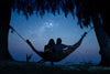 couple dans un hamac le nuit tombé tête vers le ciel étoilés