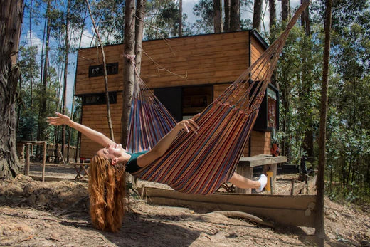 petite cabane en forêt avec un hamac en avant plan