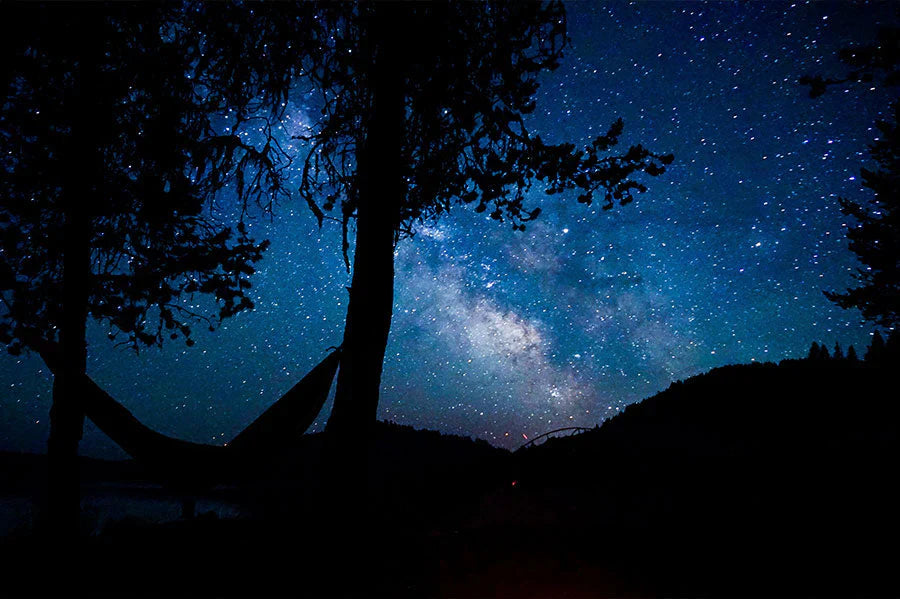 Camping en hamac sous un ciel nocturne magnifique