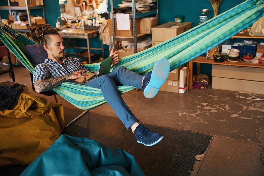 Hamac brésilien confortable installé à l'intérieur avec des coussins et une couverture, idéal pour se détendre en hiver.